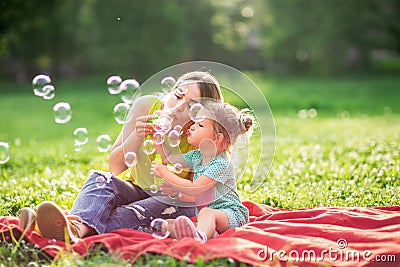 Happy Childhood â€“ Young Mother and child blows soup foam and make bubbles Stock Photo